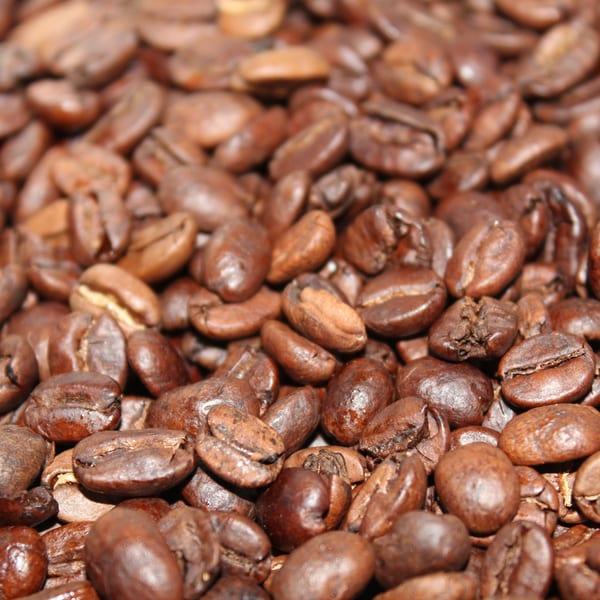 Close-up of roasted coffee beans, showcasing their rich brown color and texture for The Riv Cafe.